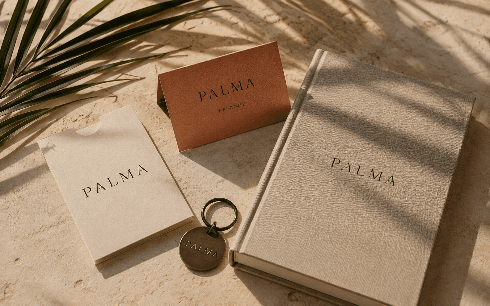 PALMA hospitality concept: linen guest journal, welcome card and room key on warm stone.
