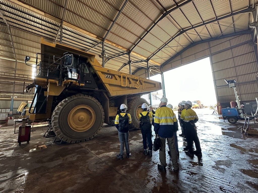 Yellow mining heavy equipment dump trucks. Aftermarket maintenance crew.