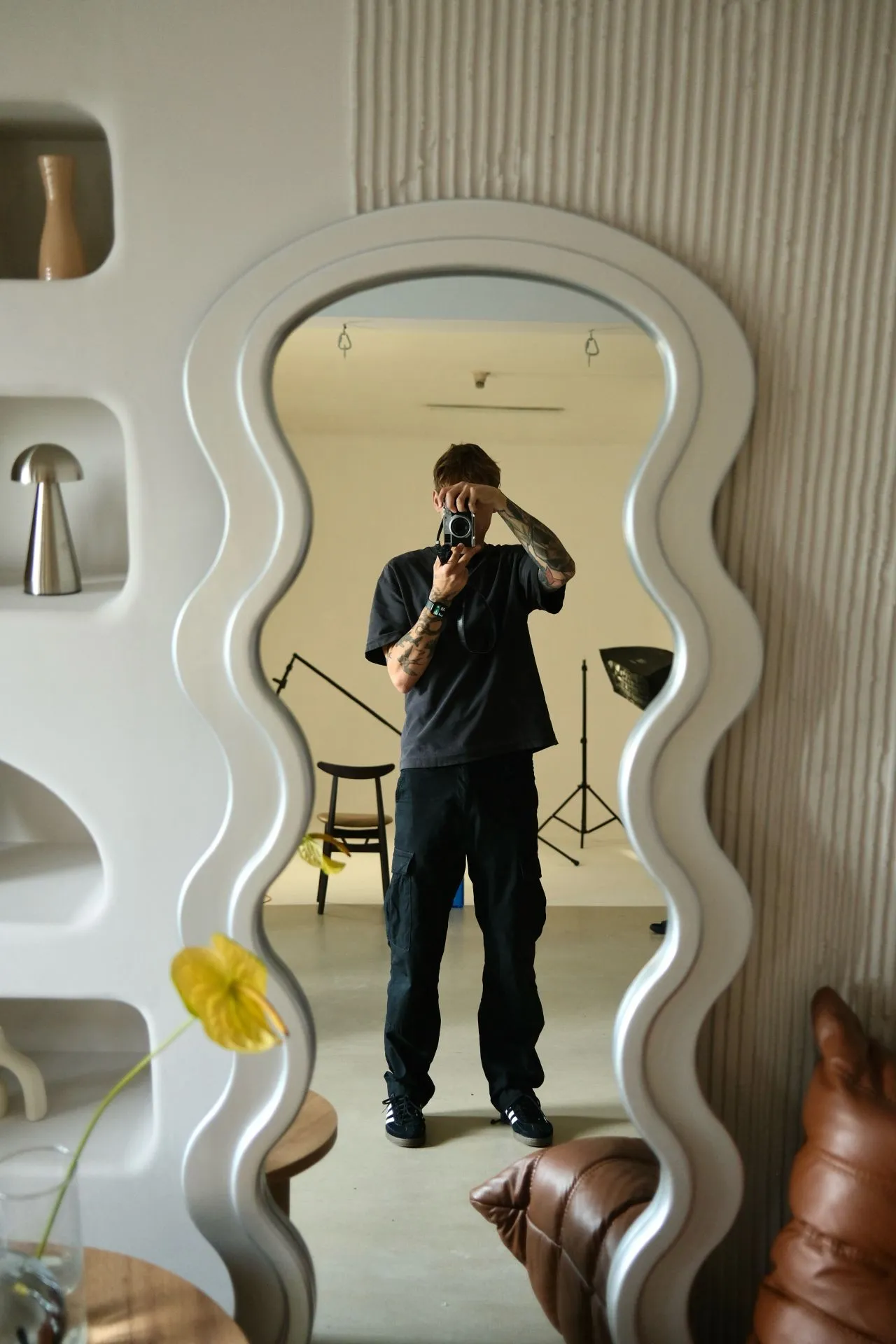 A thoughtful young person with dark hair gazes to the side, captured in soft black and white lighting.