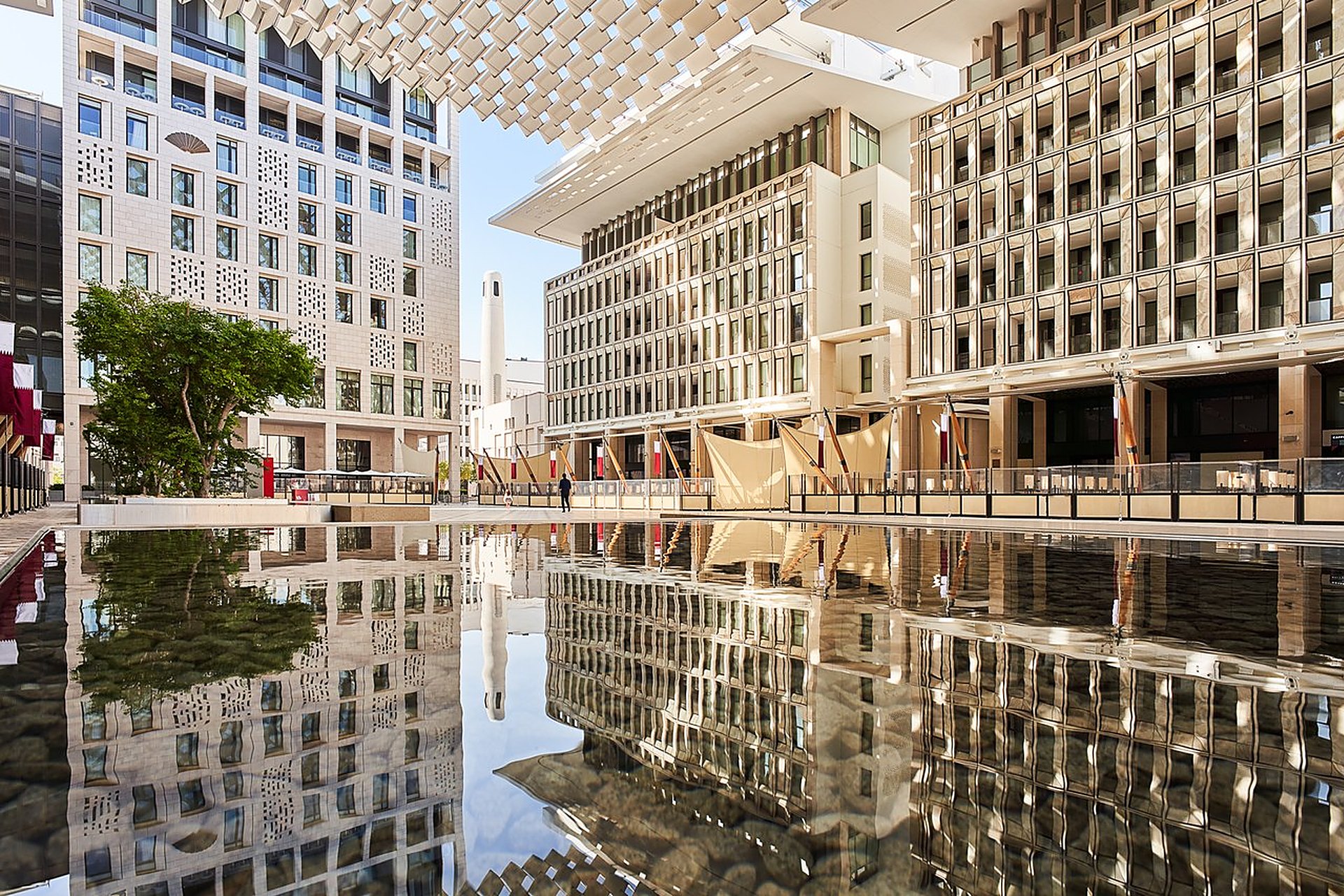 Le bassin miroir de Msheireb Downtown, le centre-ville rénové de Doha, avec ses façades claires et ses terrasses : le quartier est raccordé au réseau de froid urbain