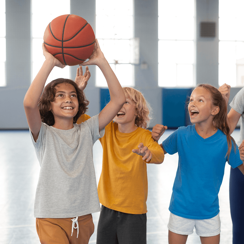 Young athletes practicing shooting and teamwork during a HOKALI school-based basketball enrichment program