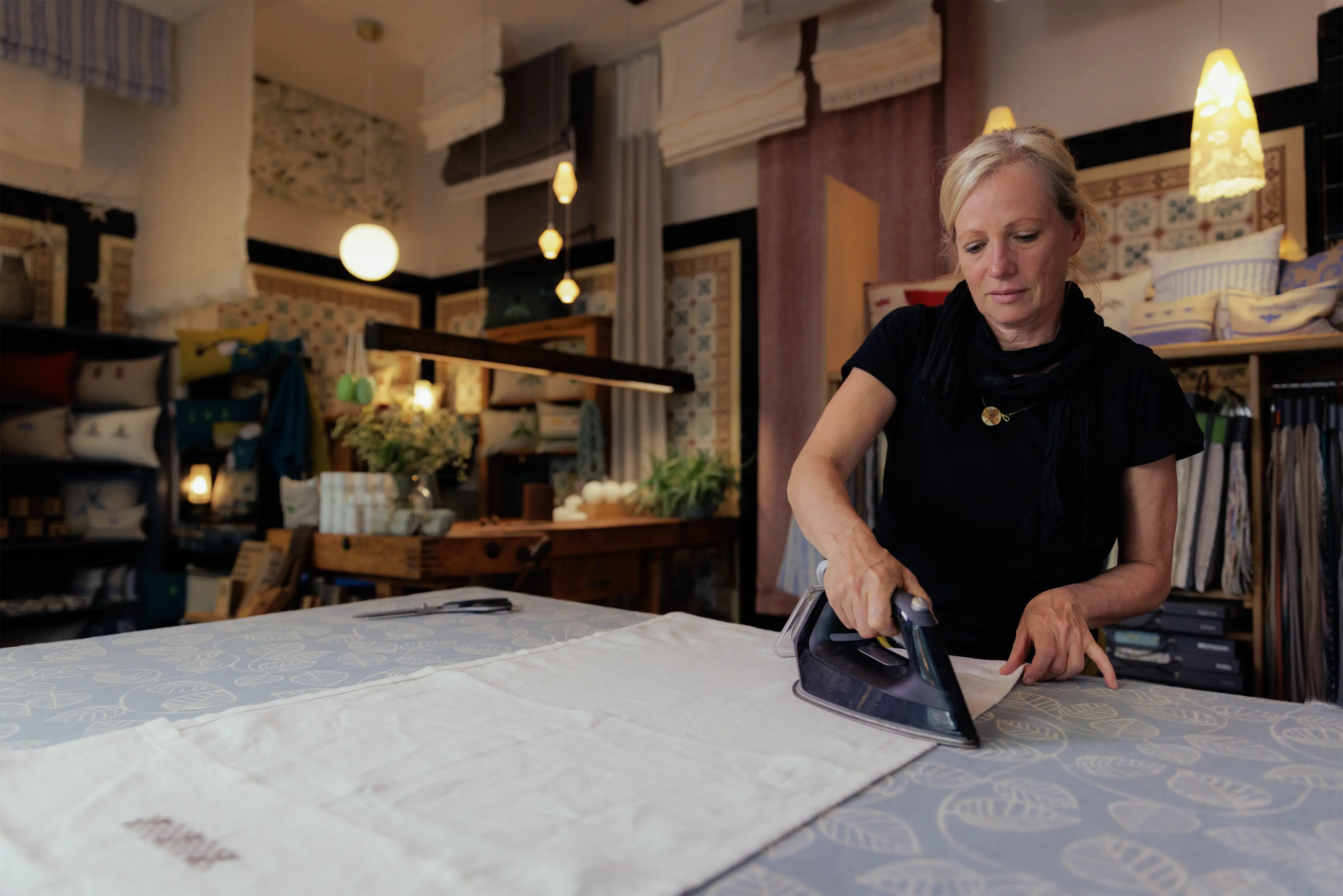 Frau bügelt Leinengardinen im Wildwechsel-Laden
