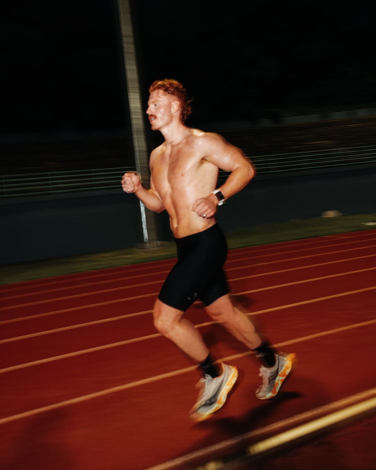 Shirtless man with sculpted abs holding battle ropes.