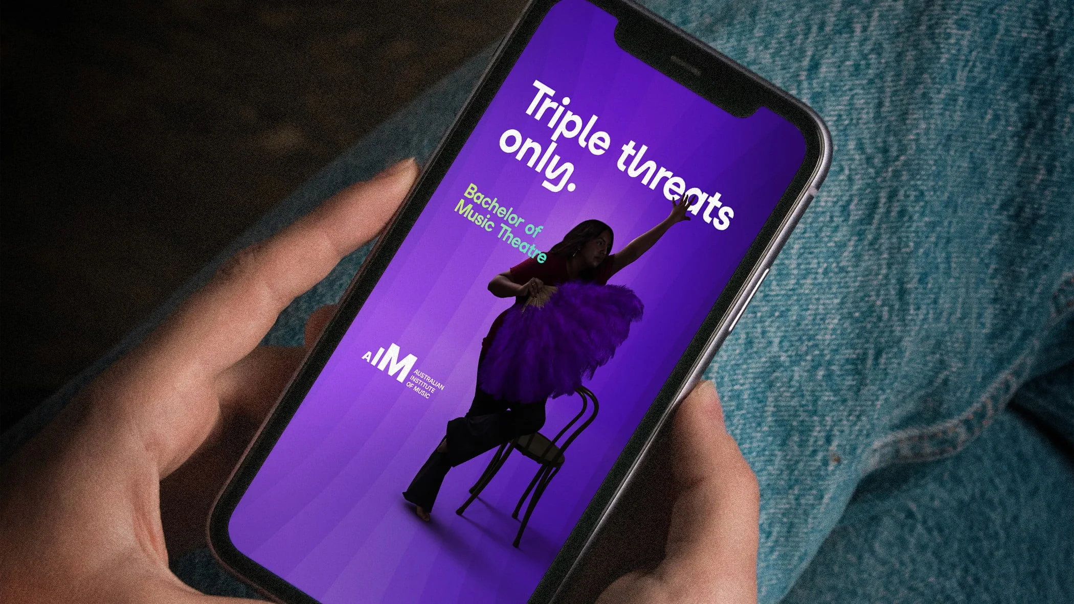 Phone showing an Australian Institute of Music ad, 'Triple threats only.', for the Bachelor of Music Theatre