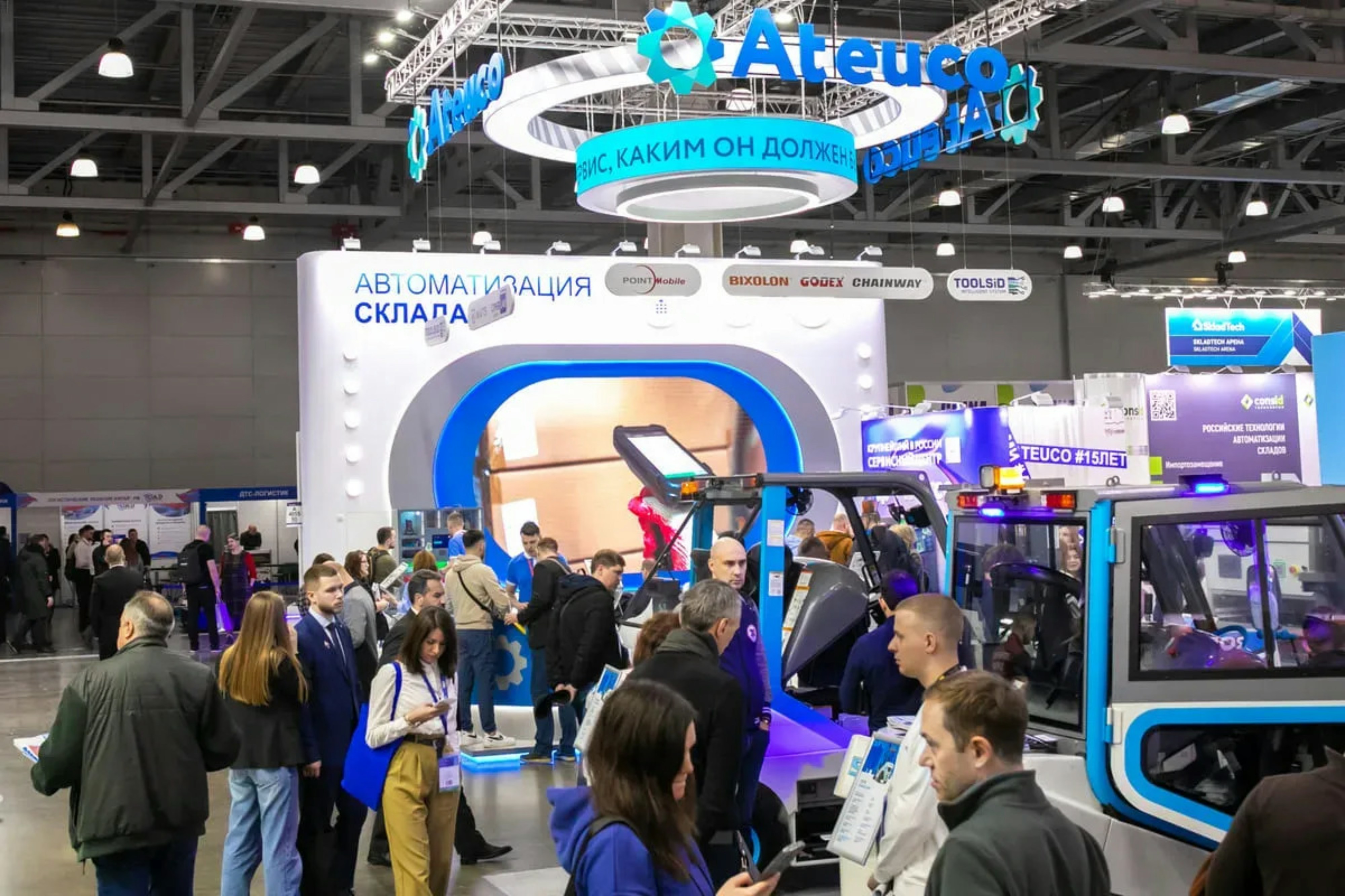 Crowd at an exhibition with booths and displays.