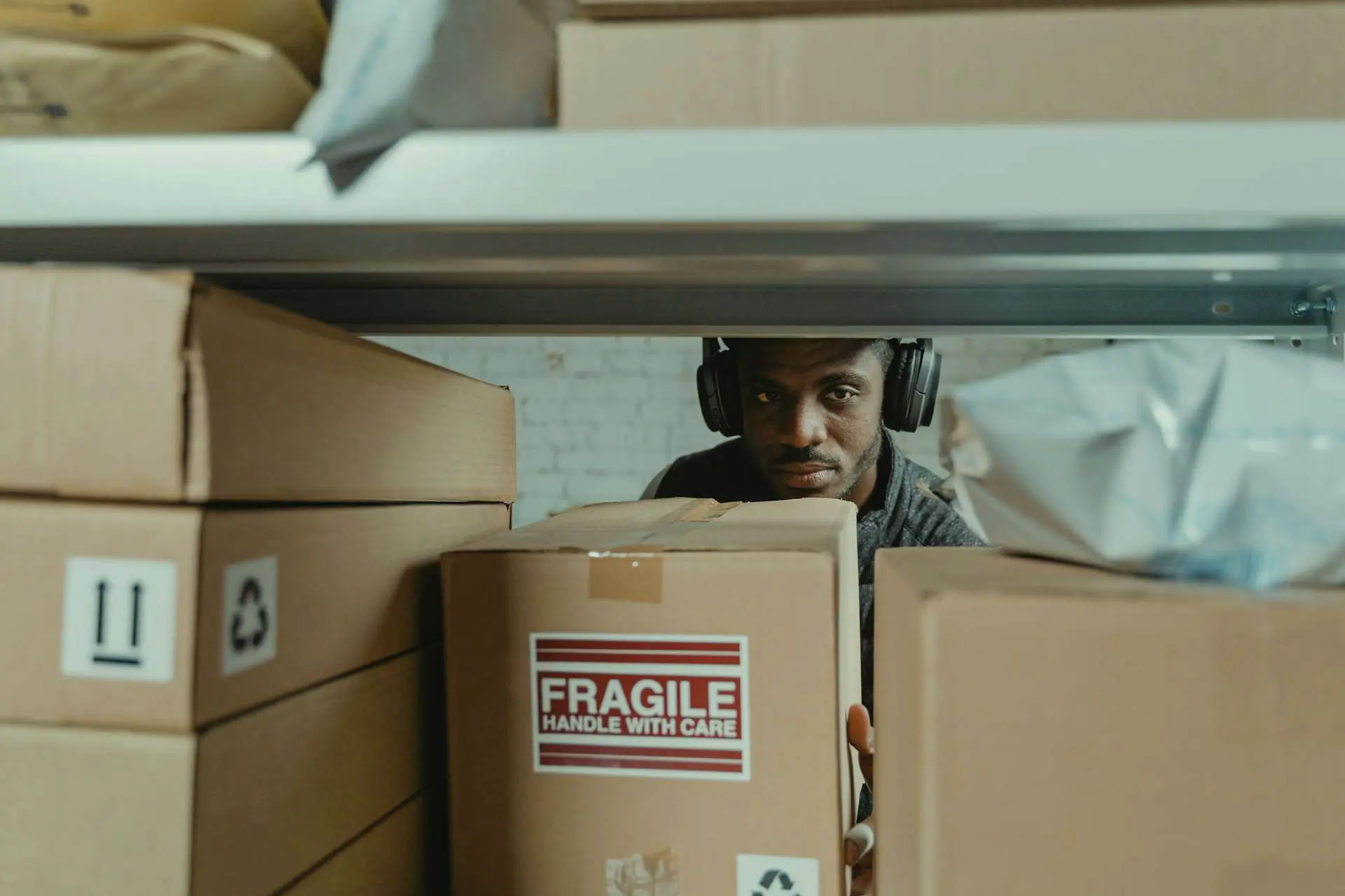 Person looking behind a shelf pacekd with fragile items.