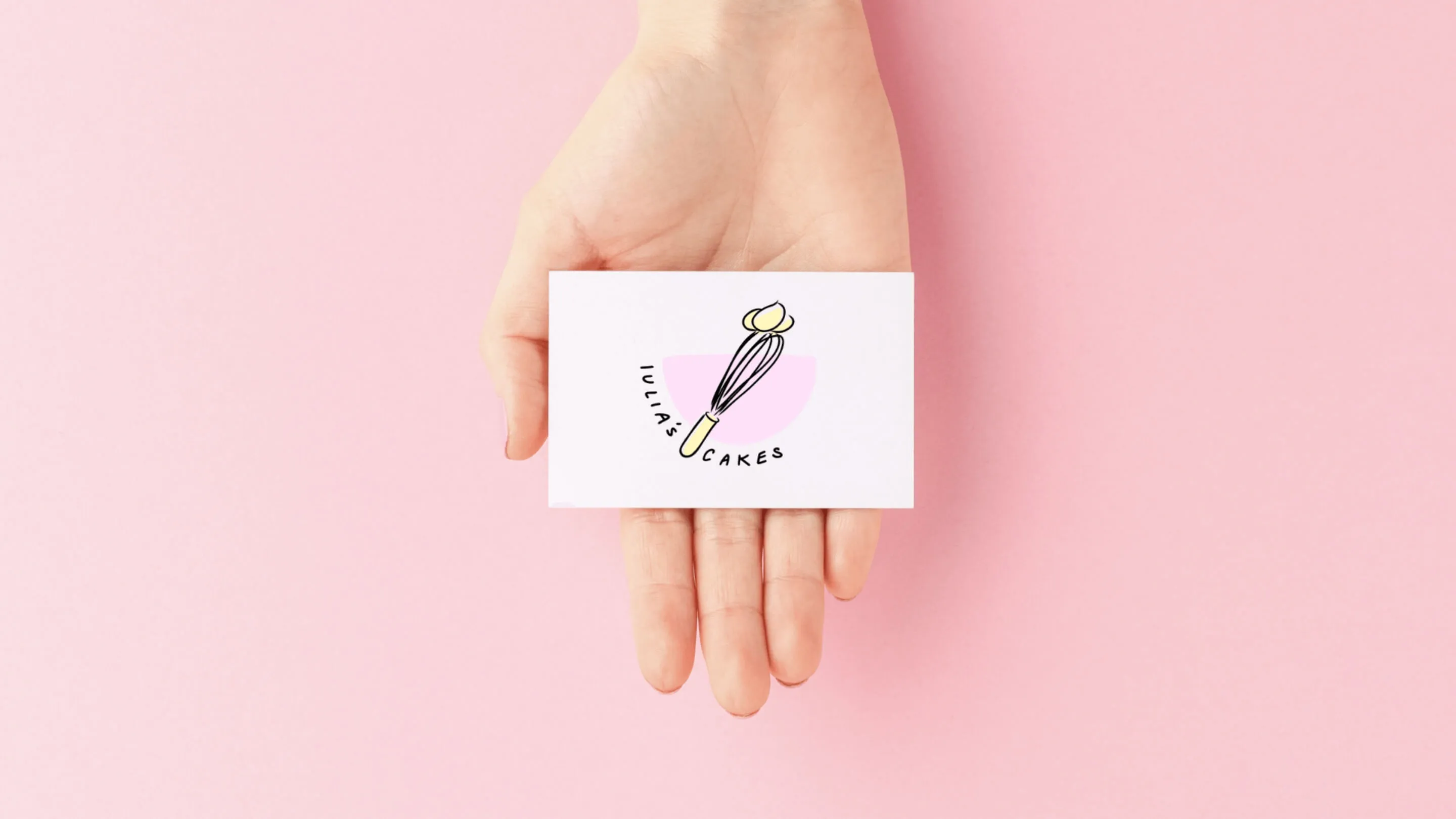 In einer offenen Hand liegt die Visitenkarte der Kuchenbäckerin mit ihrem Logo.