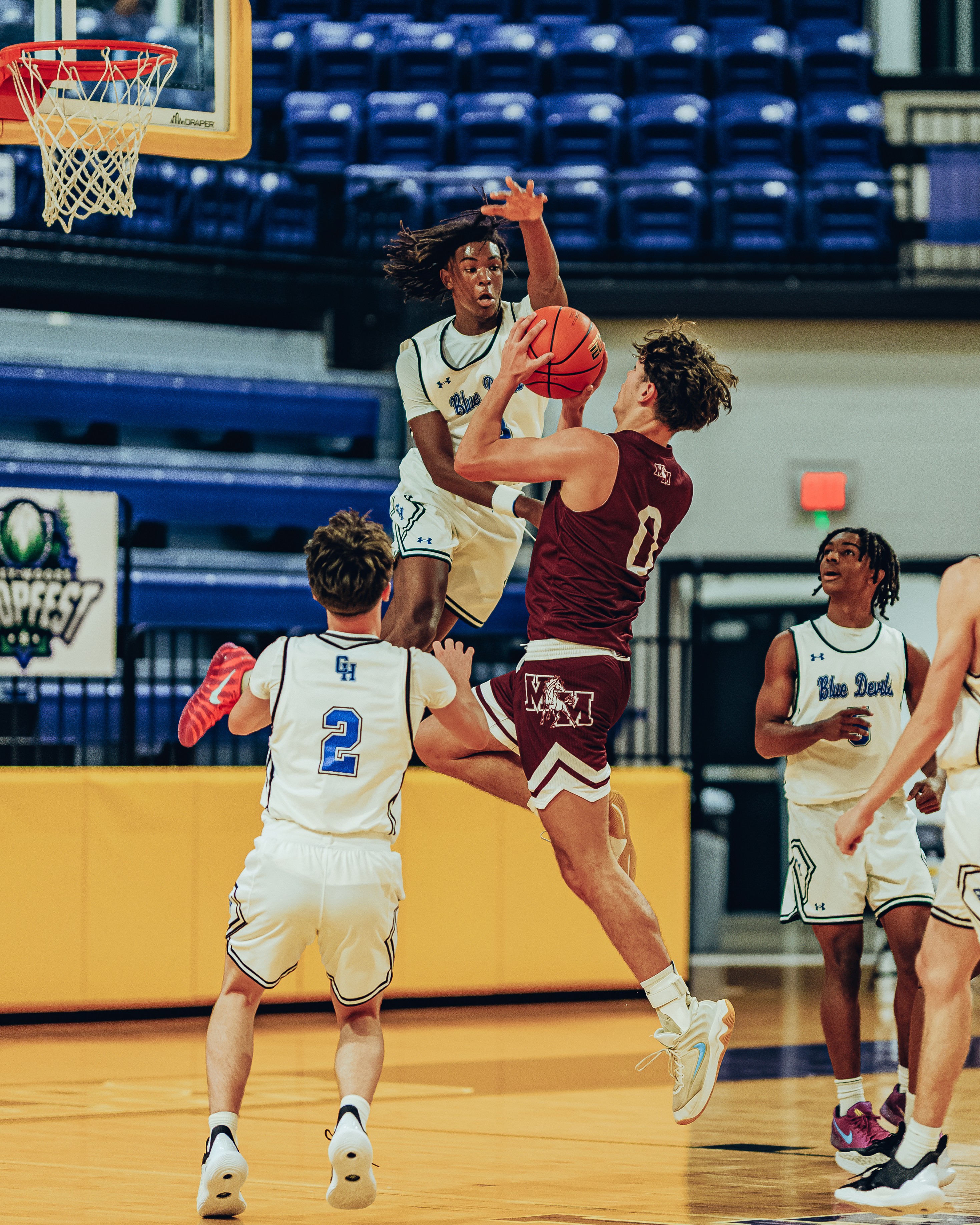 Three people sitting on a couch in a room looking at mobile devices