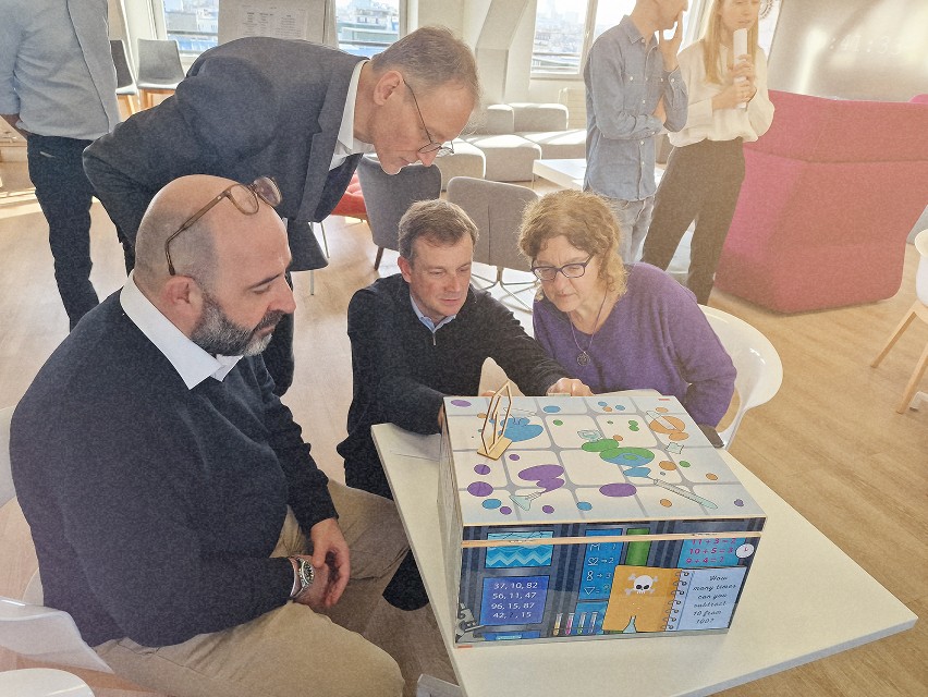 Un groupe de personnes travaillant ensemble pour résoudre des énigmes dans une salle de réunion.