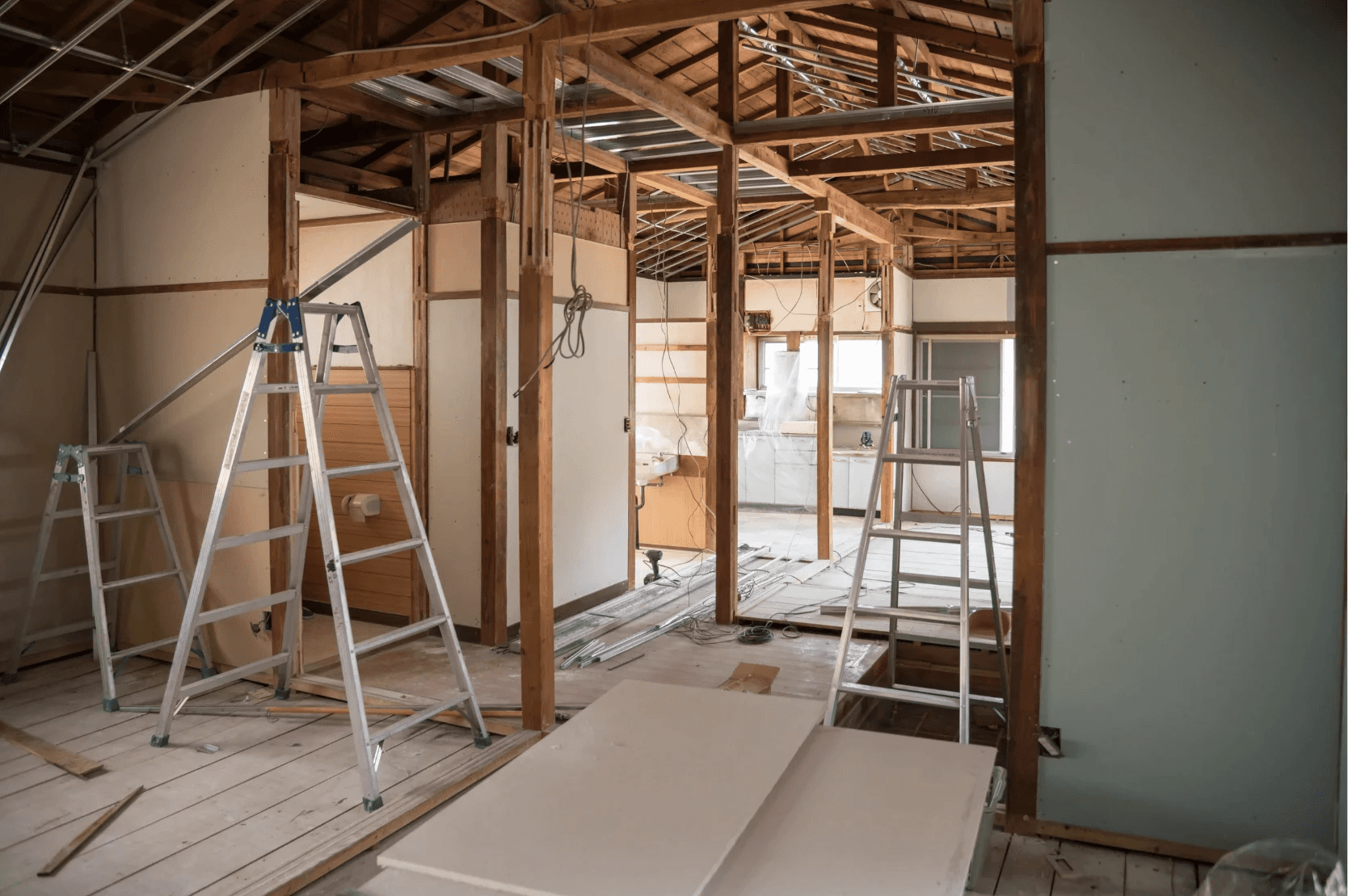 Pågående renovering med stegar, reglar och byggmaterial i ett hus under ombyggnad