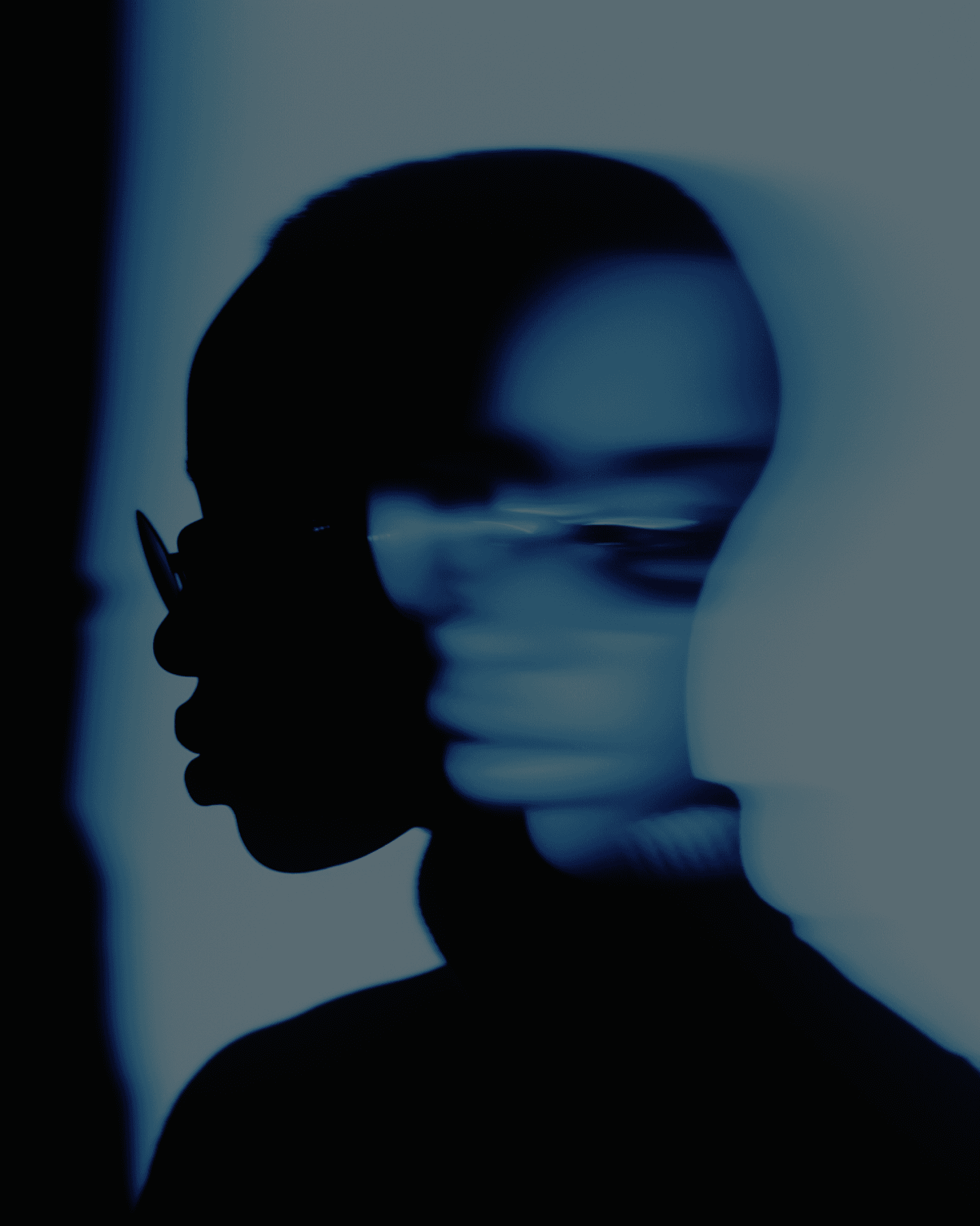 Artistic portrait of a person with dark skin and glasses, featuring a blurred effect for an intriguing look.