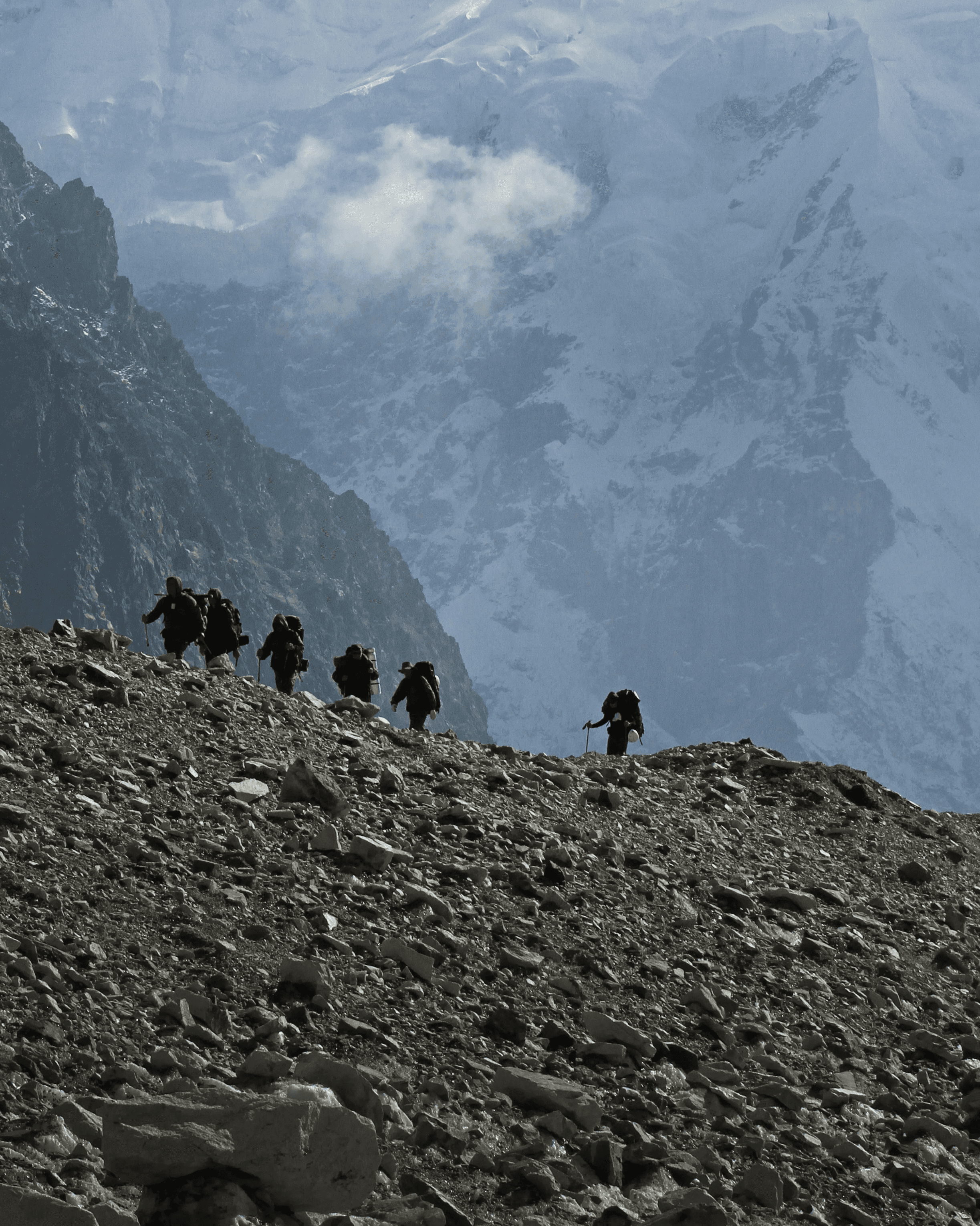 A group of people walking up a rocky hill