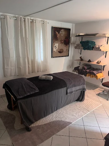 Cabine de massage Saint Denis lumineuse avec table de soin préparée, ambiance chaleureuse et décor minimaliste prête à accueillir les clients