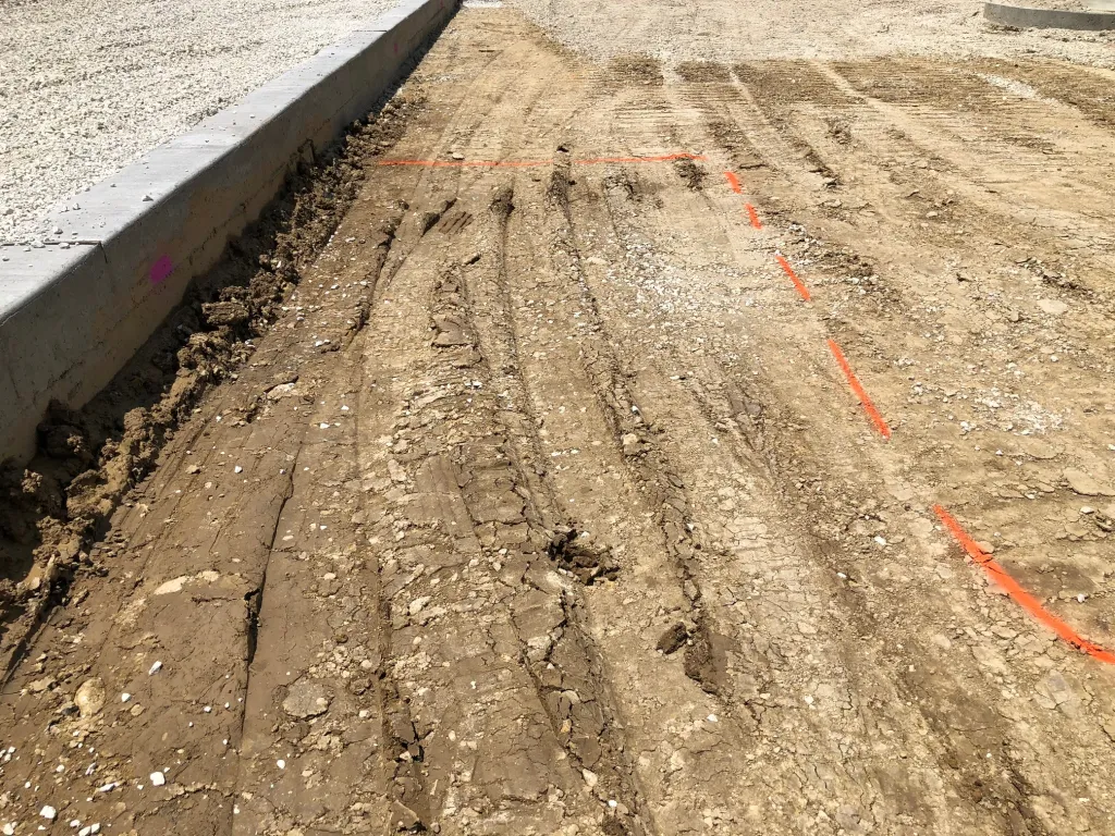 Subgrade rutting in clay soil after rain during roadway prep in Kansas City.