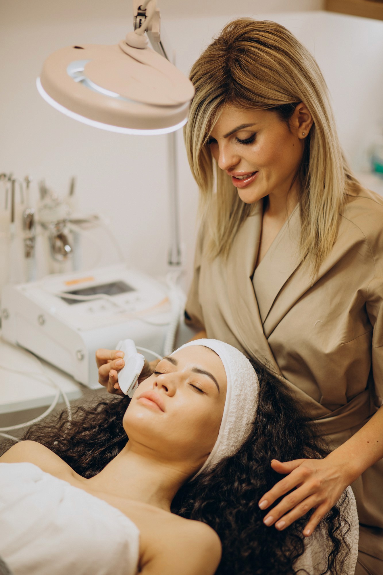 Cosmetologist performing a facial treatment on a relaxed client in a spa setting