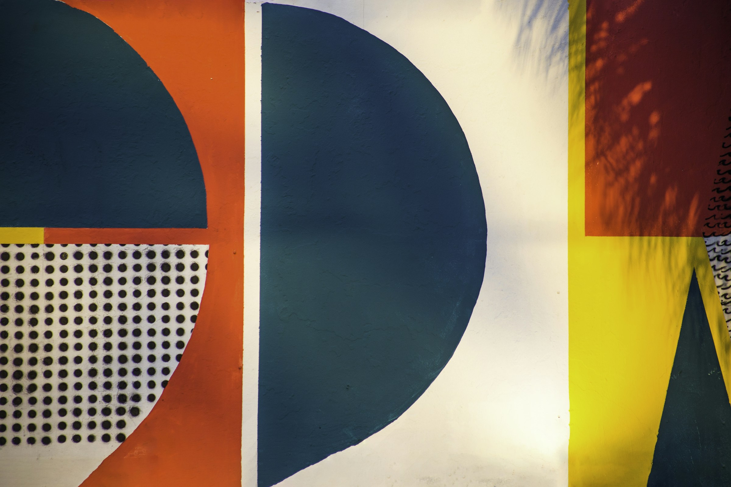 Bold geometric letterforms in navy, orange and yellow