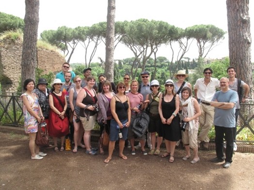 A photo of a group of people sitting in a park in Rome.