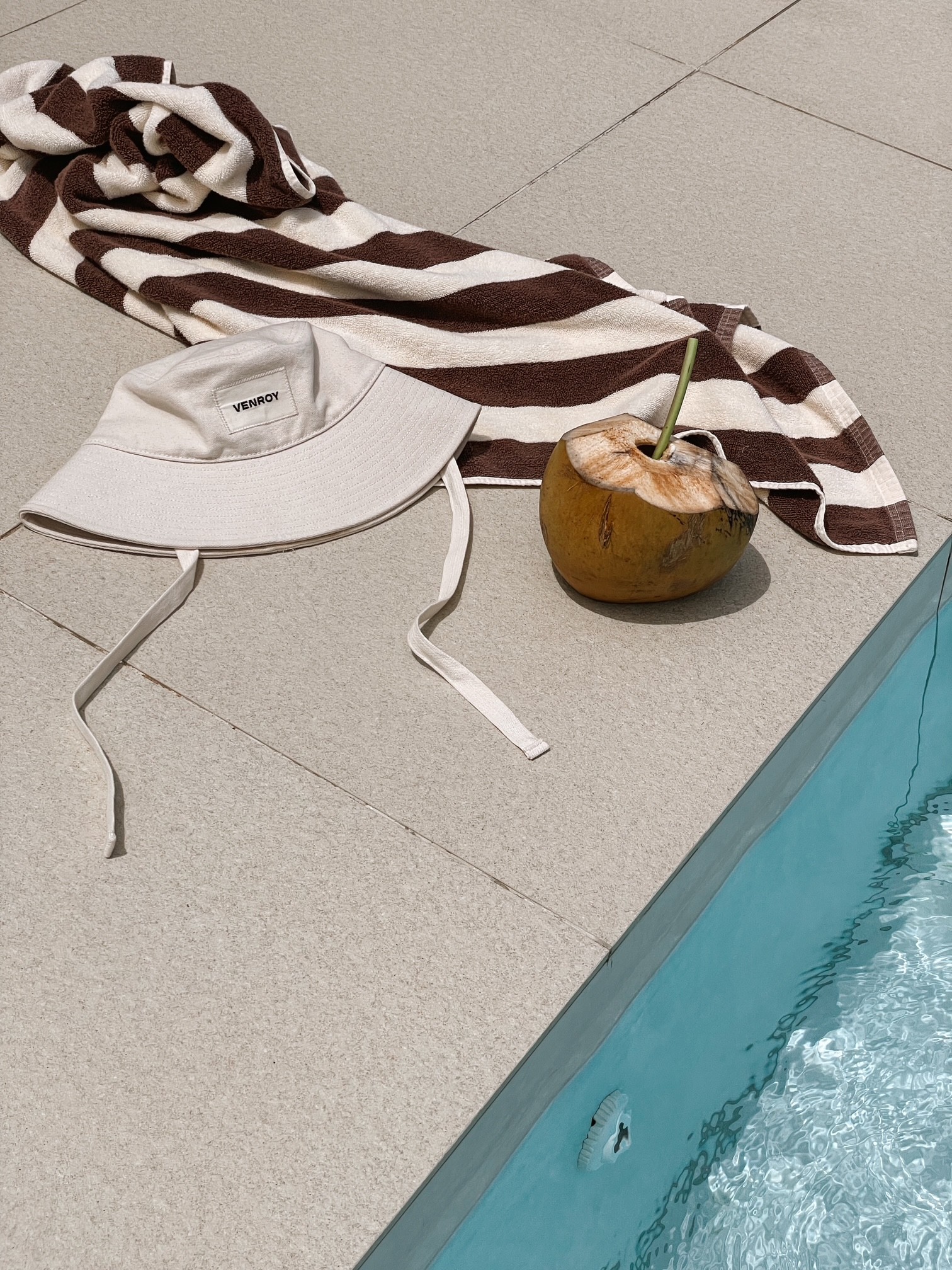 Venroy hat poolside with coconut cocktail