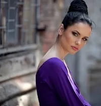 A person in a purple dress standing outside.