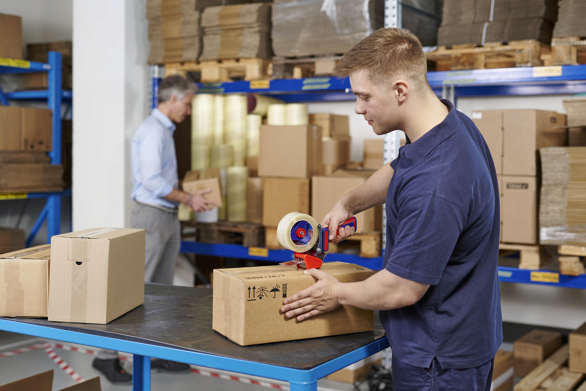Drei Arbeiter besprechen Maschinen in einer hellen Industrieumgebung und demonstrieren dabei Teamwork und Zusammenarbeit.
