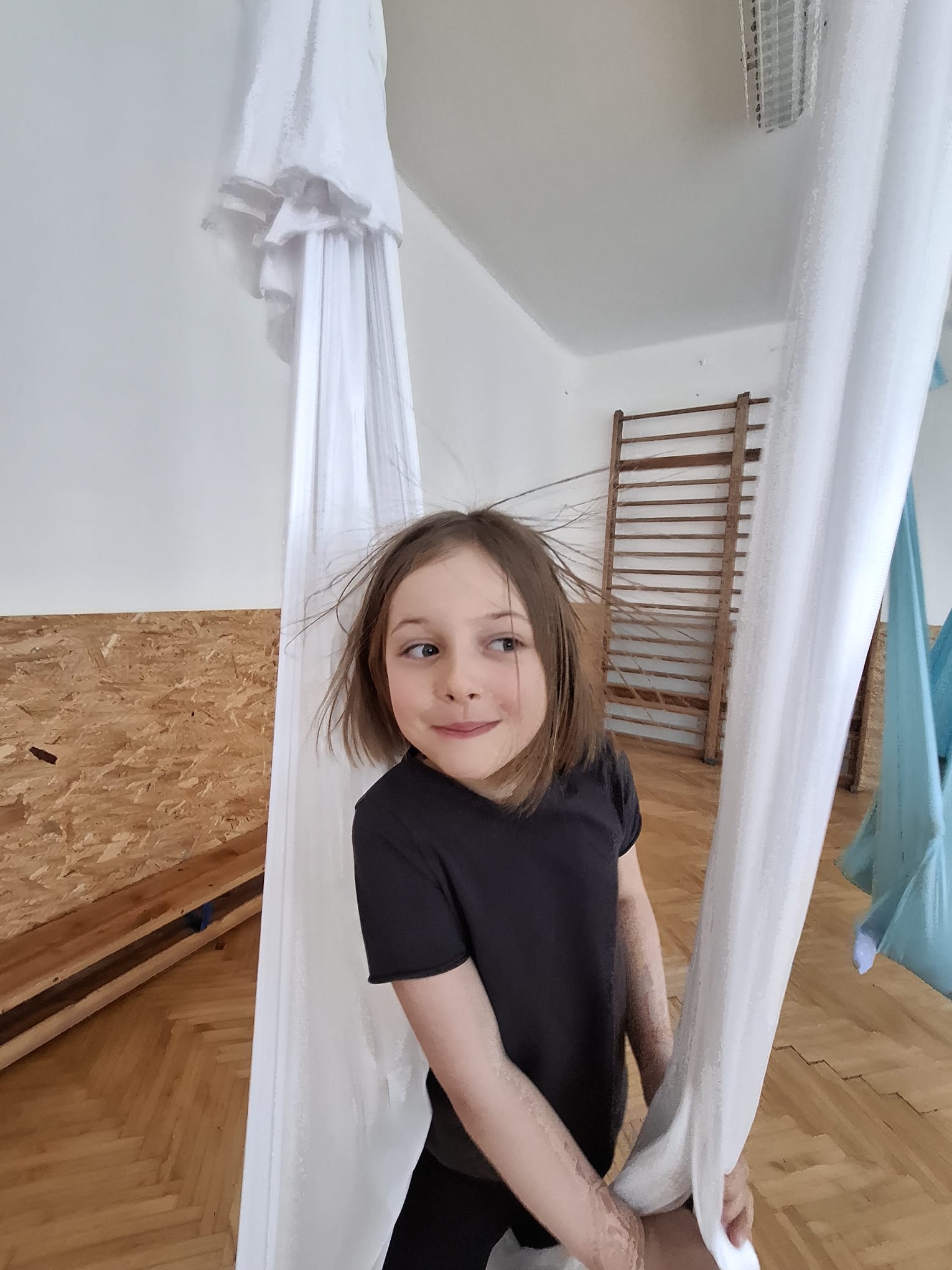 Děti v lese zkoumají vzorek vody v plastové krabičce pomocí lupy.