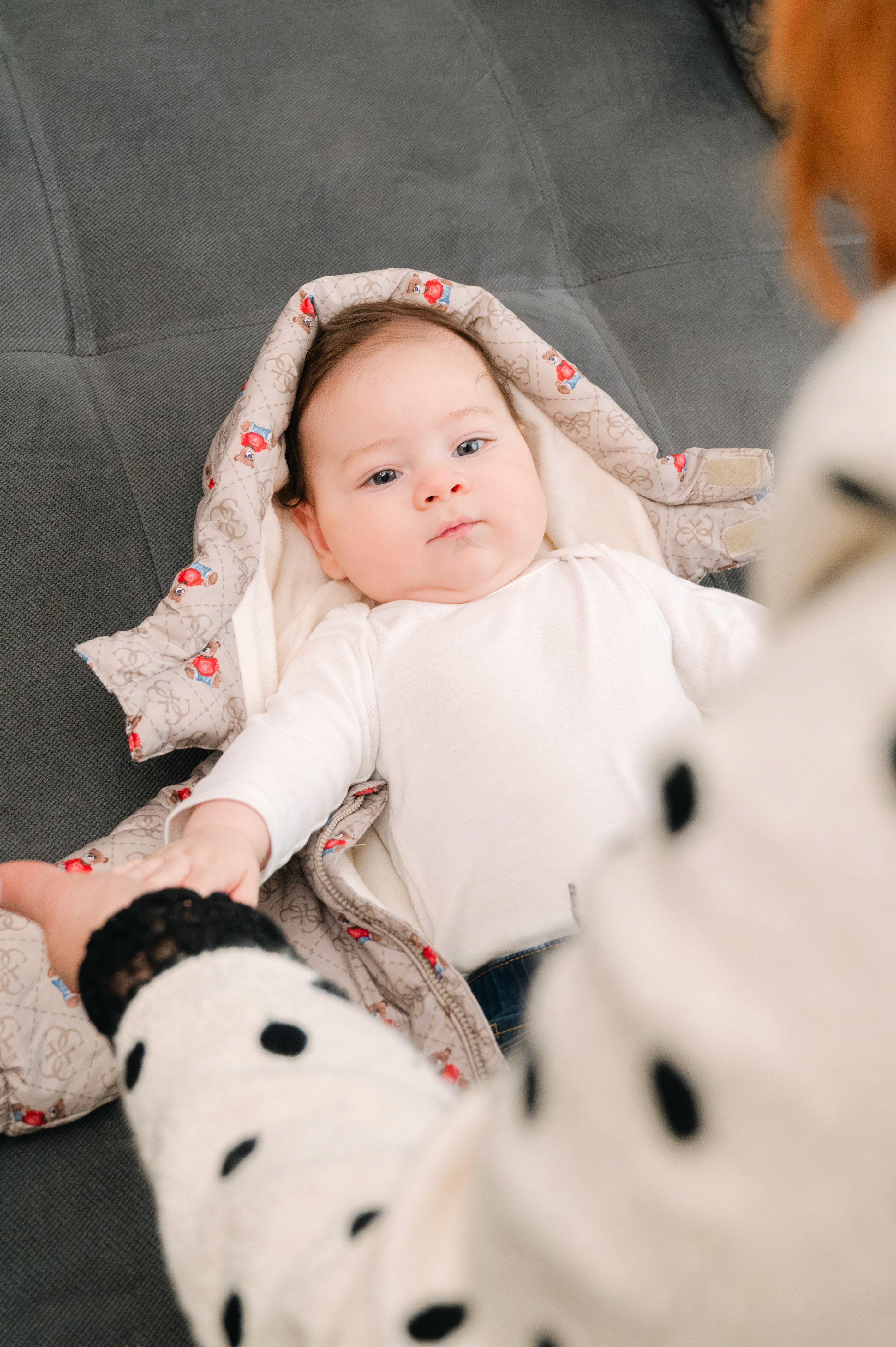 Bebeluș îmbrăcat în costumaș alb pentru ceremonia religioasă.