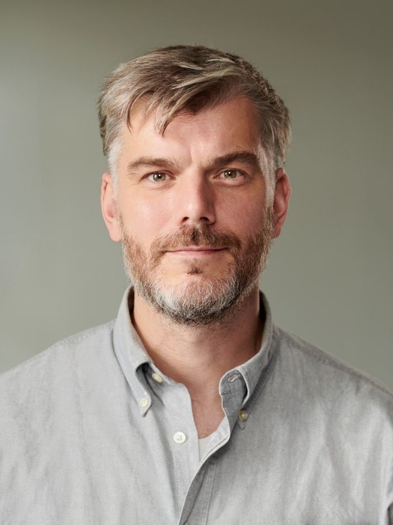  Porträt von Robin Bräunig mit Hemd vor neutralem Hintergrund 