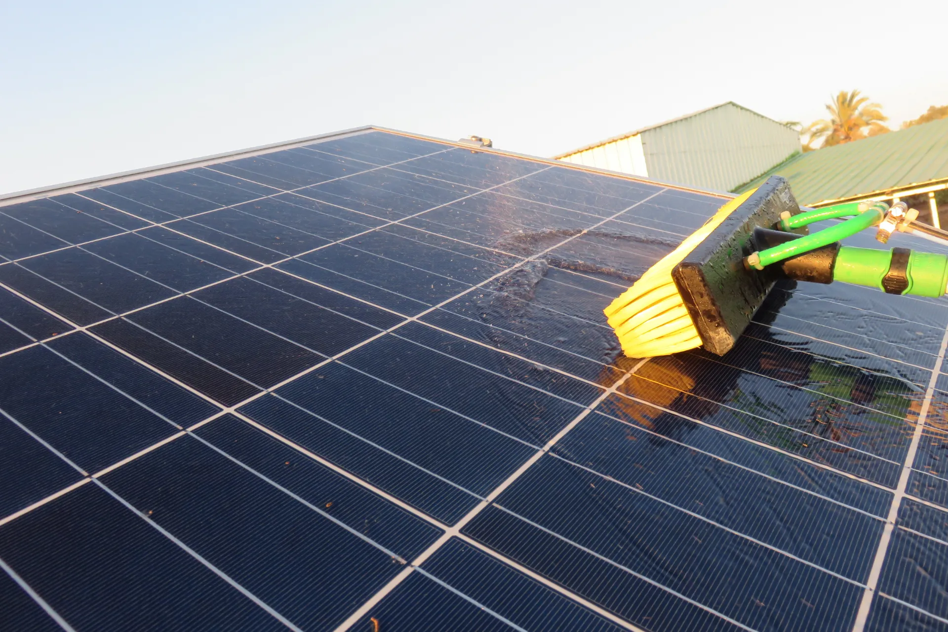 Eine PV-Anlage die gerade mit einer Bürste gereinigt wird.