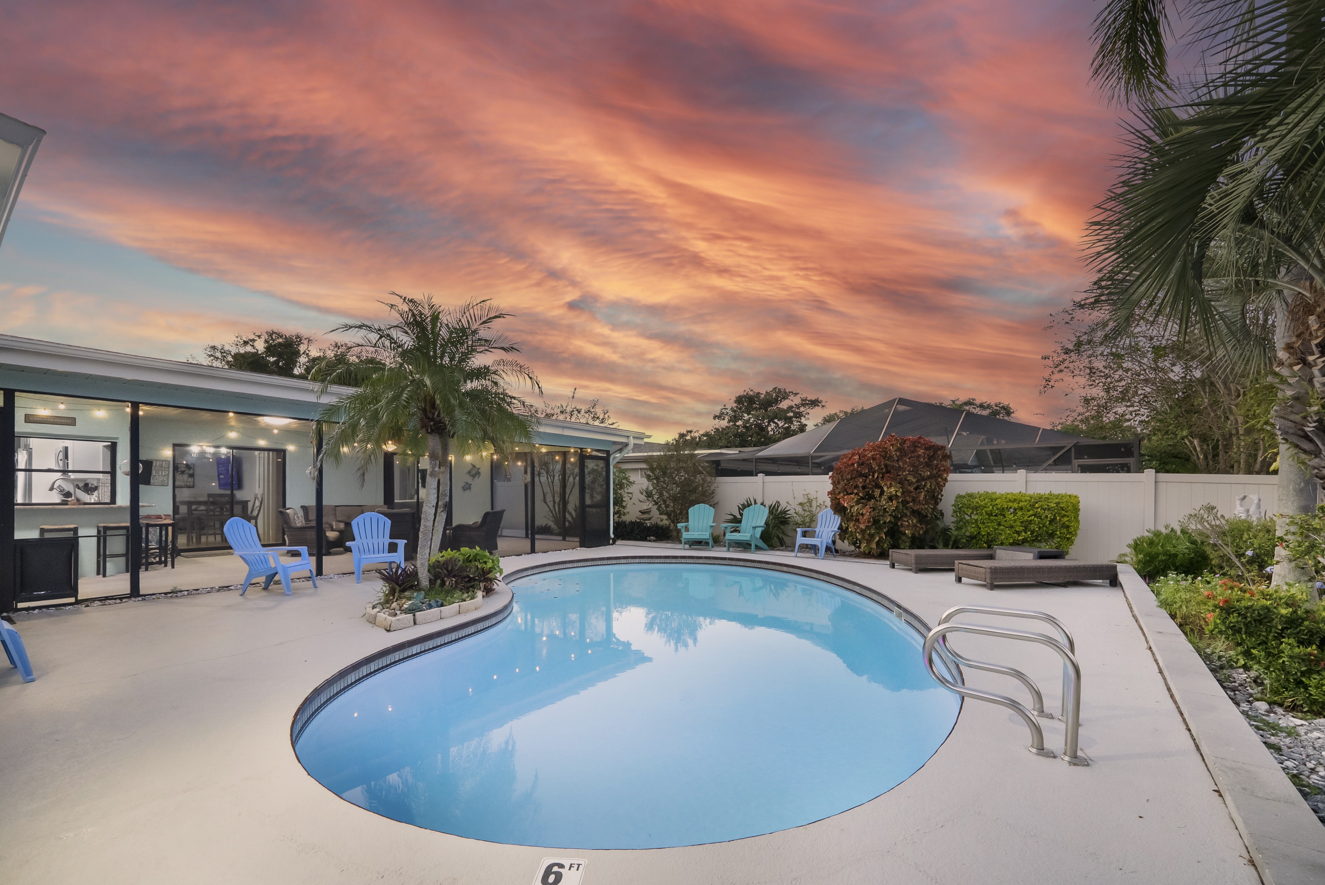 Backyard view with pool and sunset.