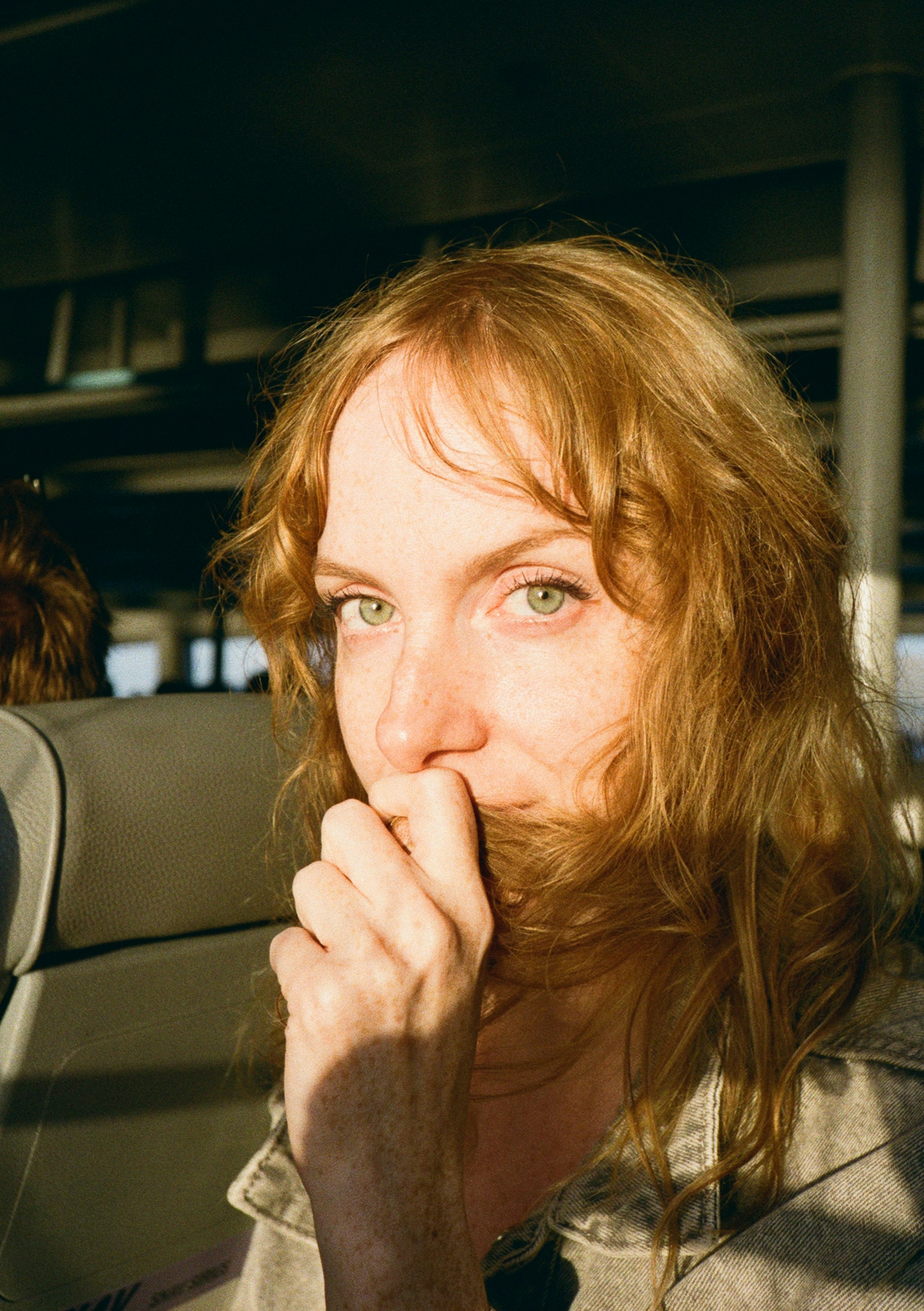 Woman with red hair covering mouth with hair