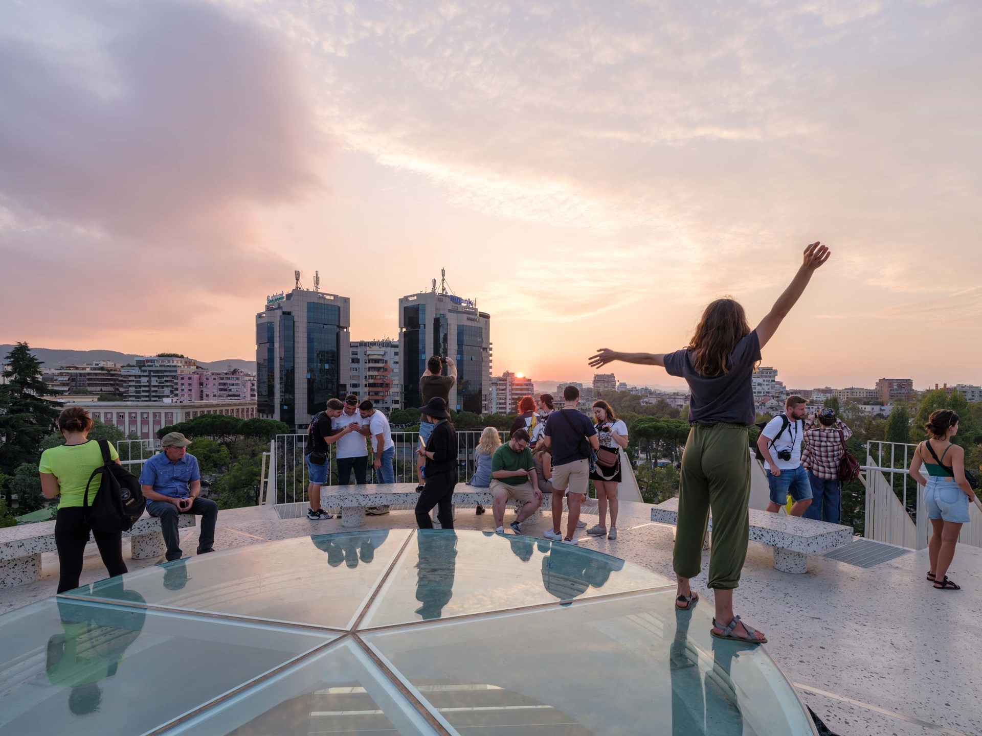 Aerial view of a winding road surrounded by dense green and yellow trees, showcasing nature’s vibrant colors.