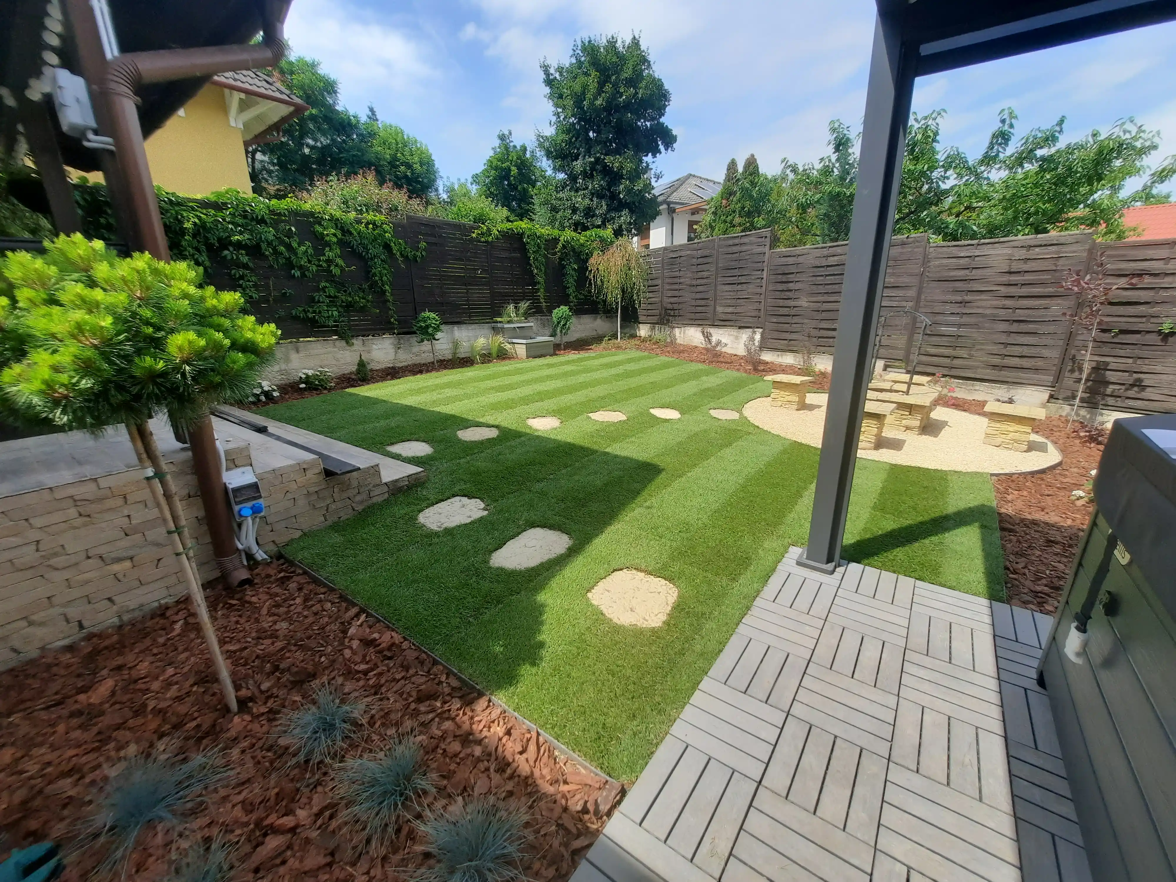 Sziklakert épitése olajfával modern családi ház mellett