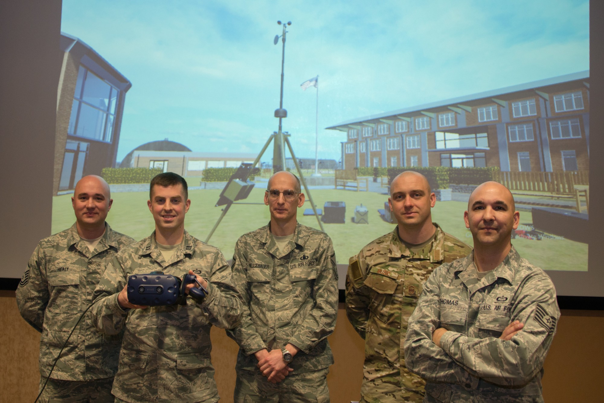 Airmen smiling for photo with SHIIFT's virtual weather training tool behind them