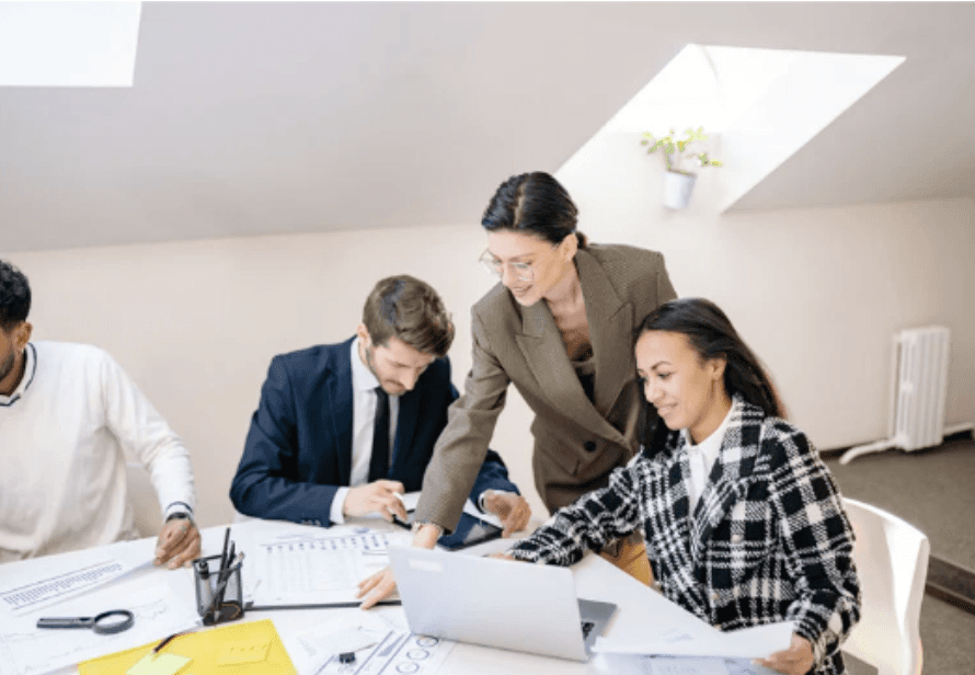 two women sitting at a table looking at a computer screen
