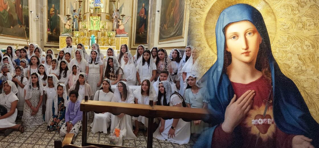 four boys laughing and sitting on grass during daytime