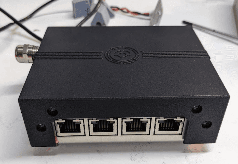 Closed EMC-shielded chassis with four RJ45 PoE ports and a sealed cable gland
