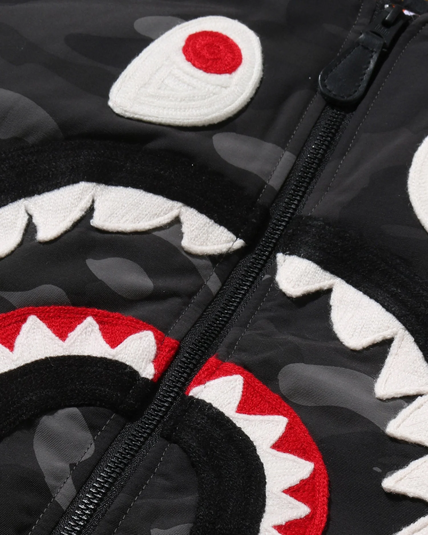 A Bathing Ape shark face in close-up: chenille teeth and eye on black camo