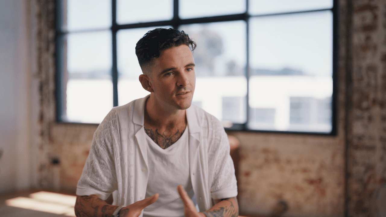 Tom Noske wearing a white shirt with sunlight in the background