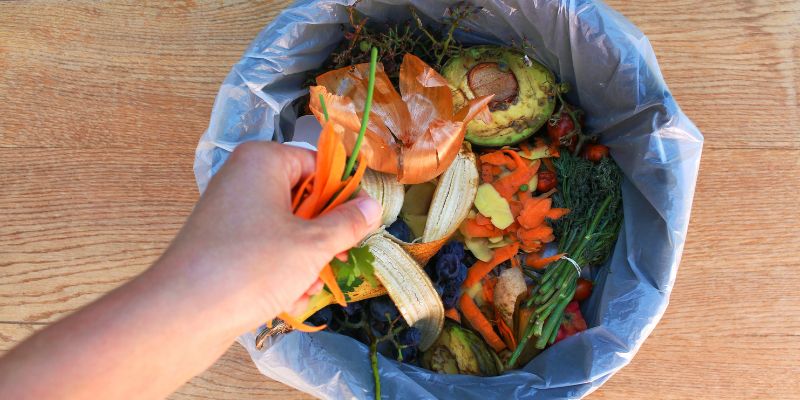 A person throwing out food waste
