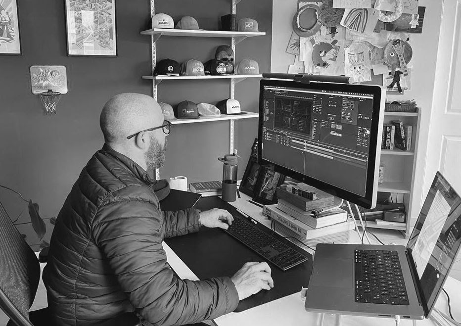 A thoughtful young person with dark hair gazes to the side, captured in soft black and white lighting.