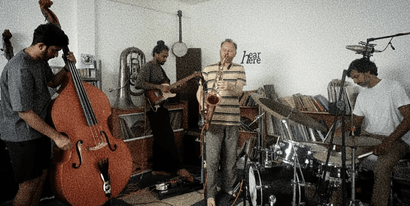 A man playing a drum in front of a group of people