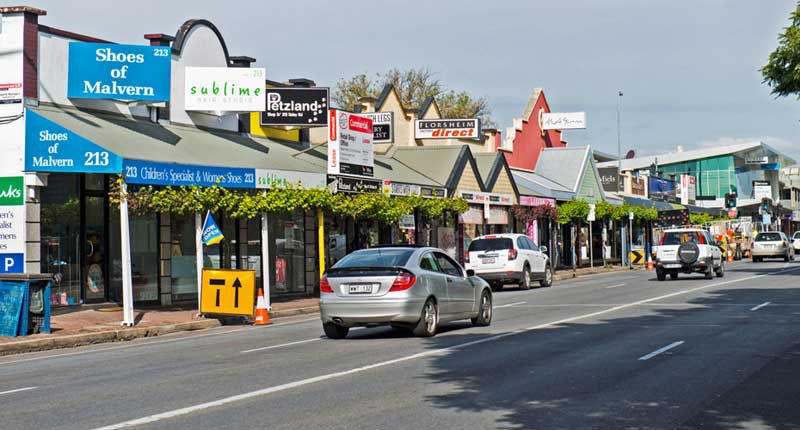 two cars parked in a parking lot next to a tree