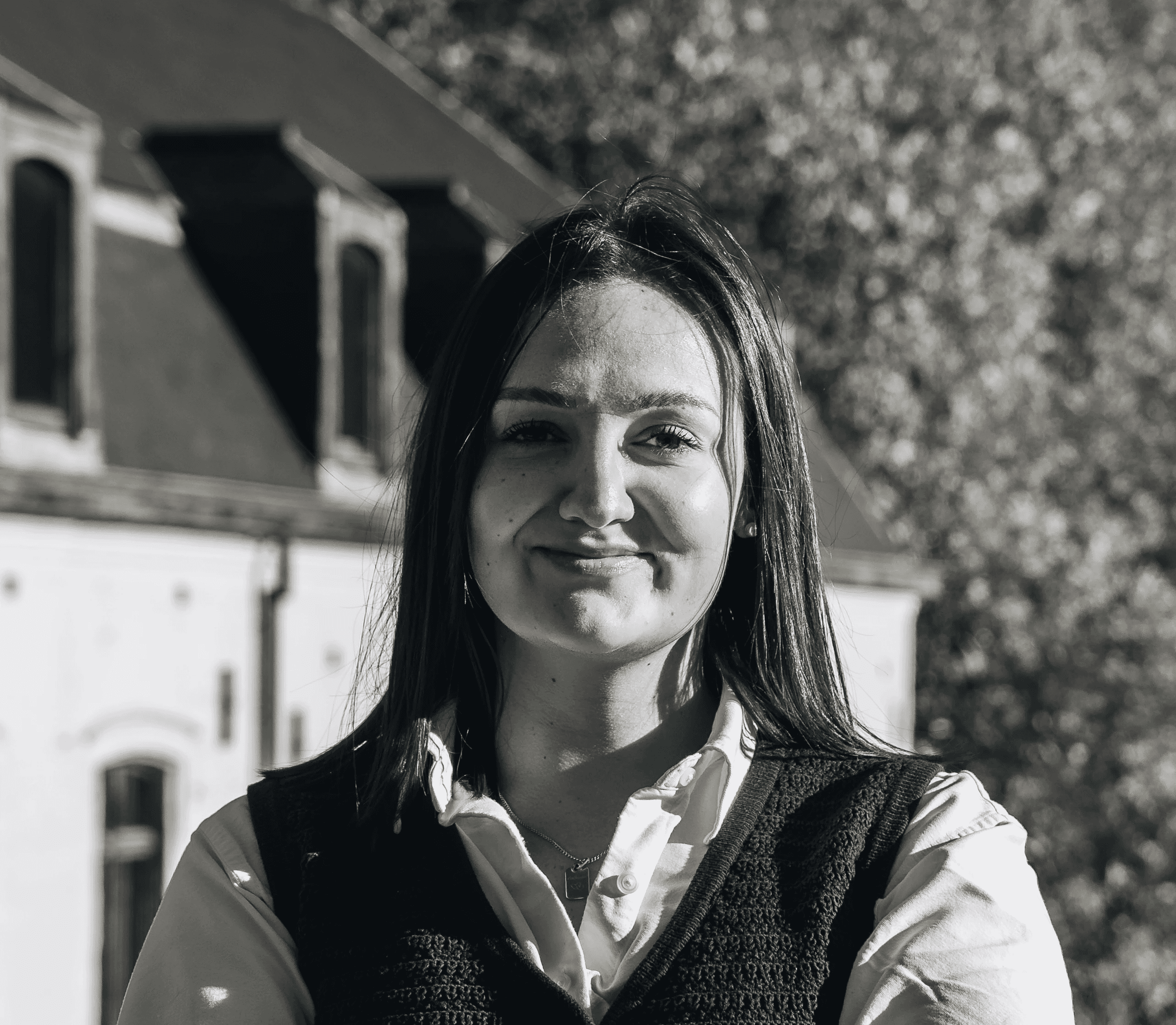 Portrait of a laughing person with curly hair wearing a white shirt