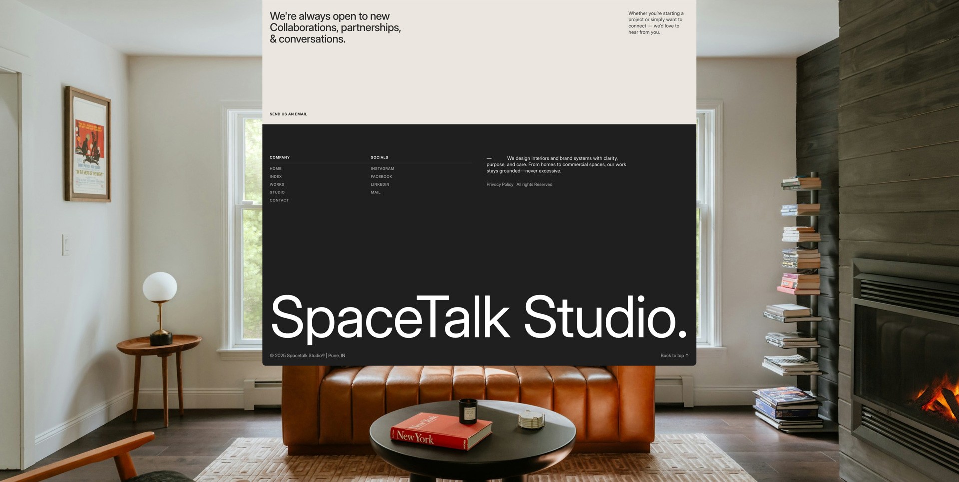 In a cozy, modern living room featuring a brown leather couch and a lit fireplace, a website overlay showcases SpaceTalk Studio with links to company information and social media.