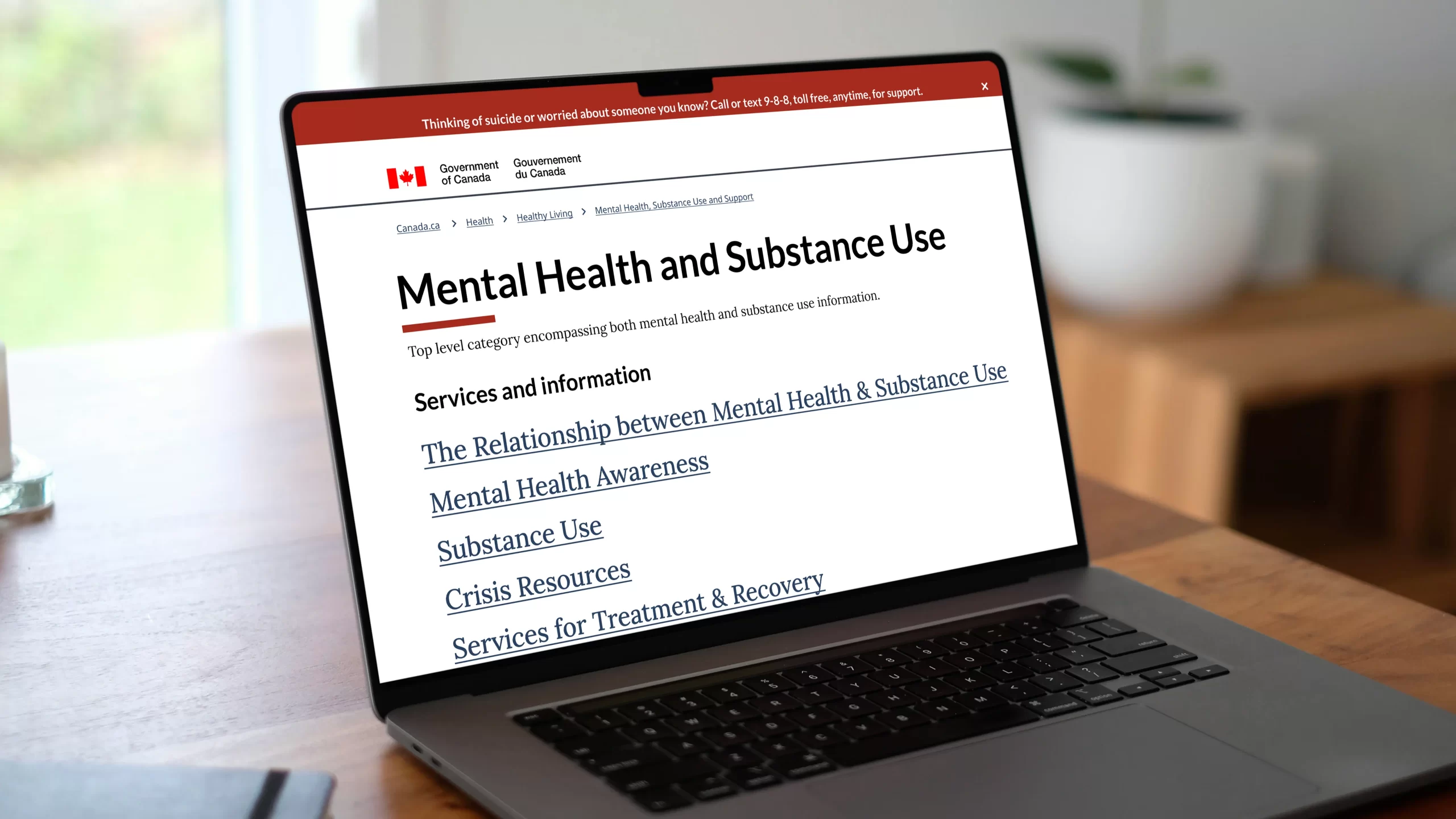 A mockup for a Macbook placed on a table with the Health Canada website open