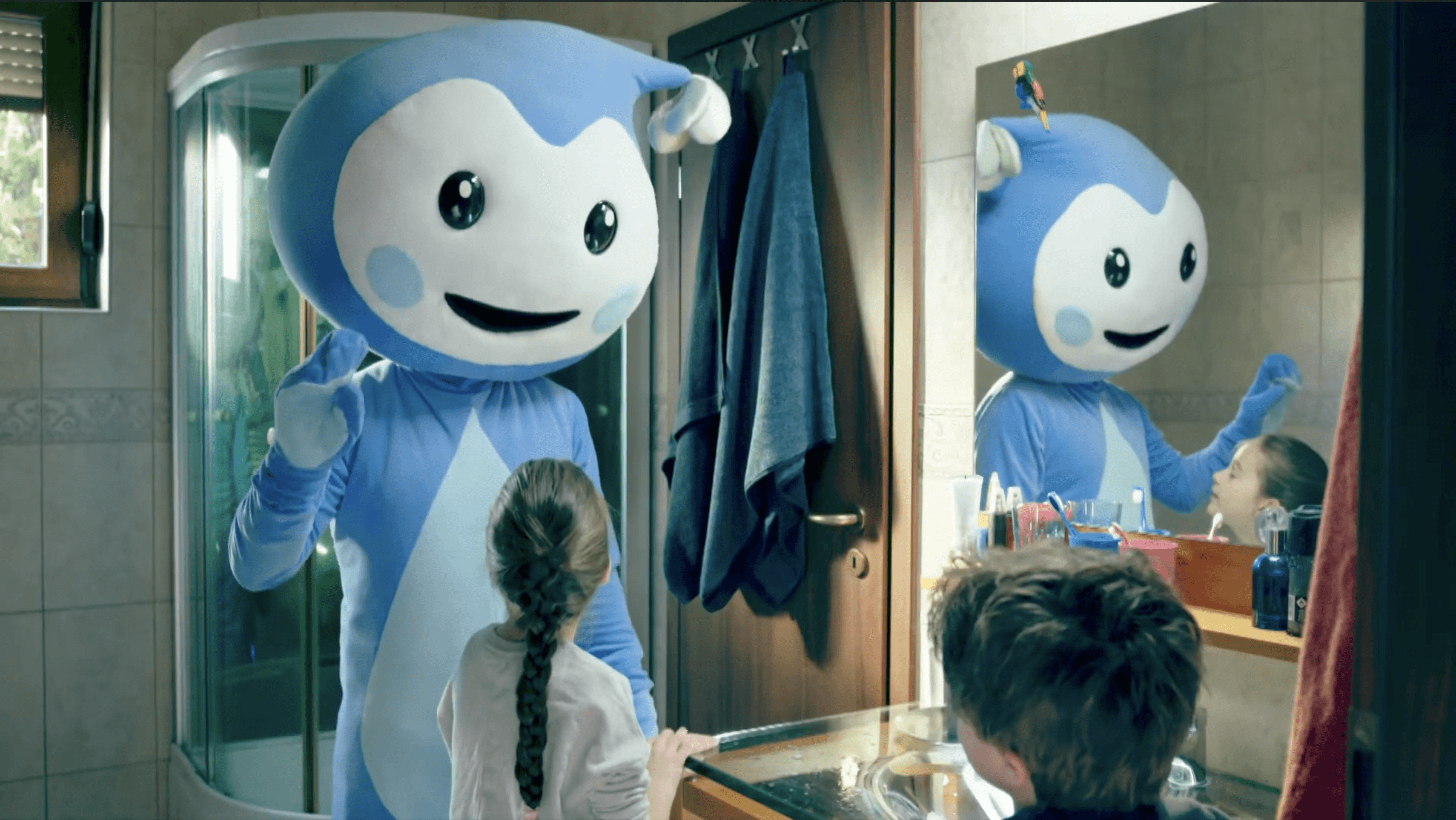 Cseppbarát kék kabalafigurája a tükör előtt a kézmosást tanítja a gyerekeknek.