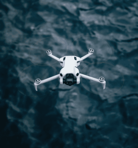 Drone flying over a body of water.