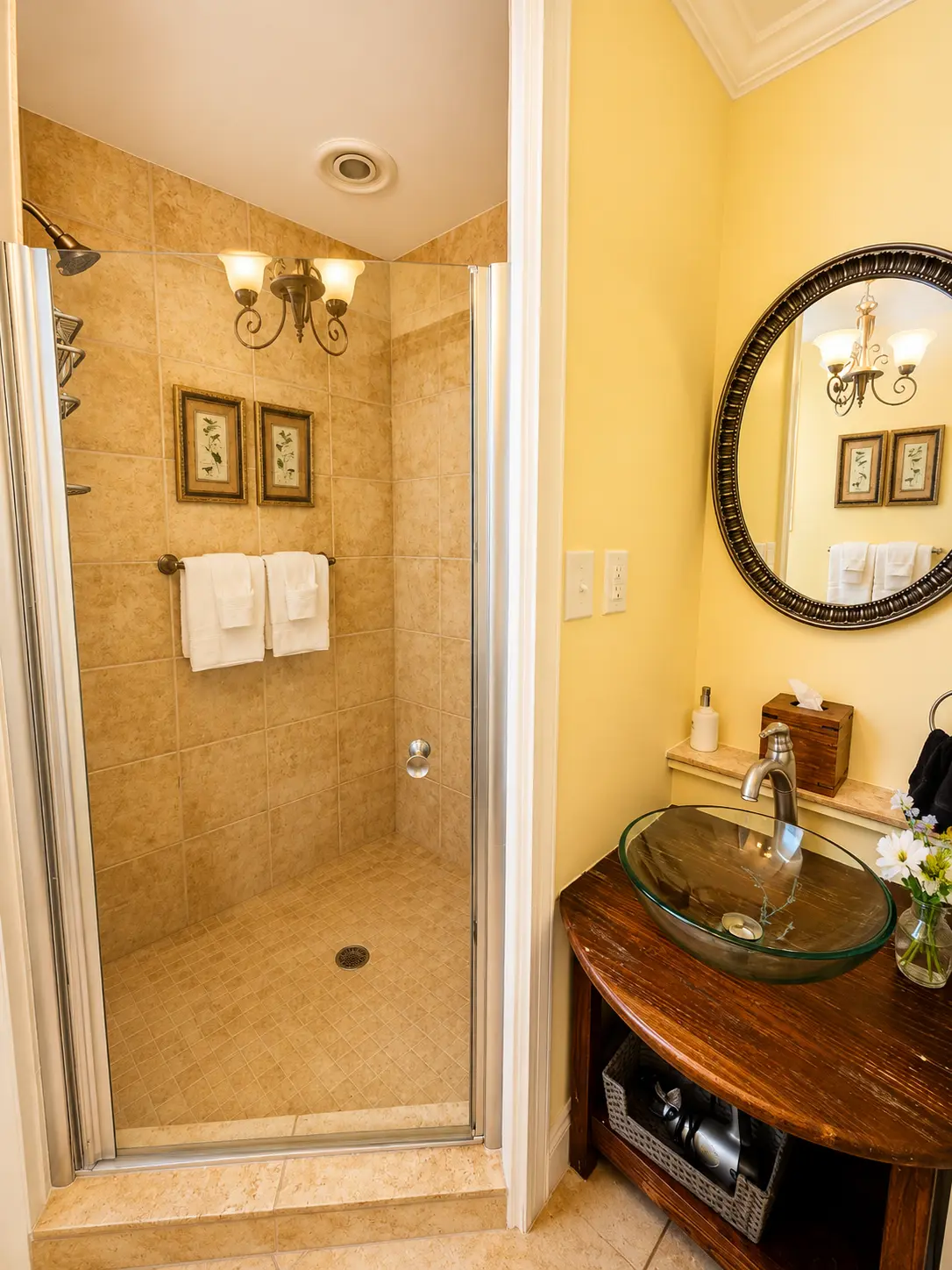Accessible walk-in shower with bench and a vanity with glass vessel sink.