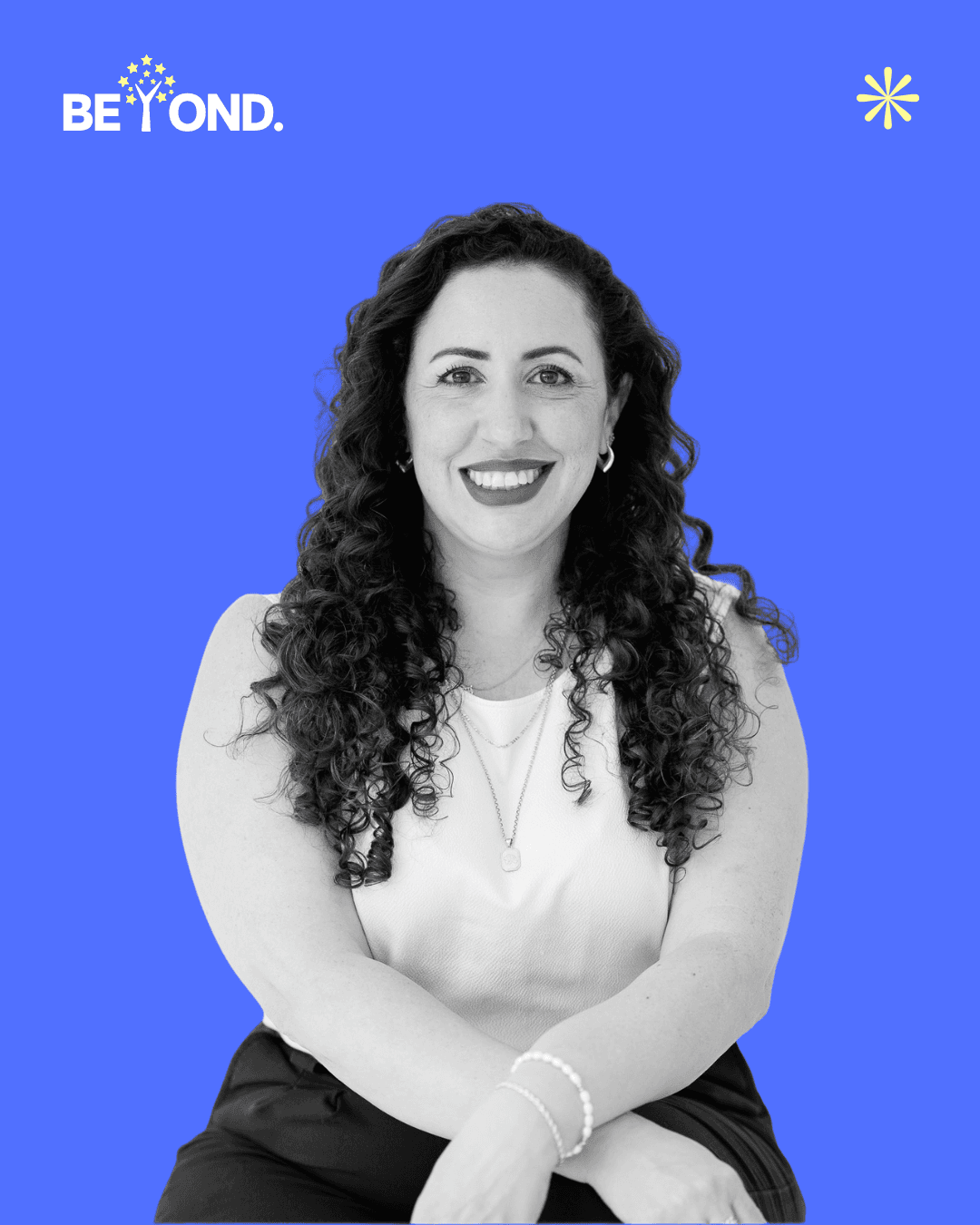 A confident person with short, styled hair and a leather jacket poses against a dark backdrop.