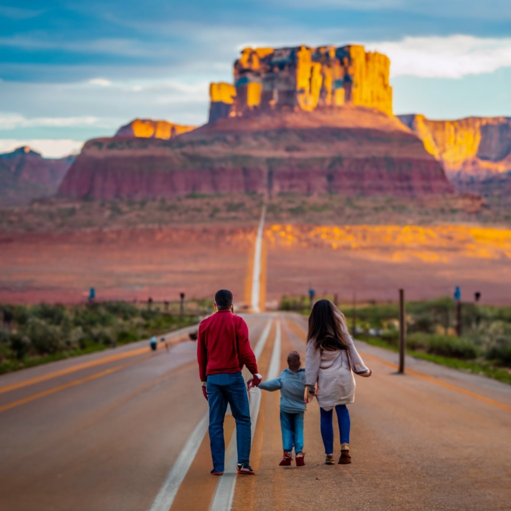 Happy family standing in front of a U.S. landmark, representing the benefits of obtaining a Permanent Resident Card.